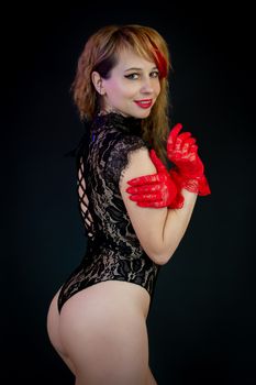 A stylish studio portrait of a woman in lace lingerie with red gloves, exuding elegance and charm.