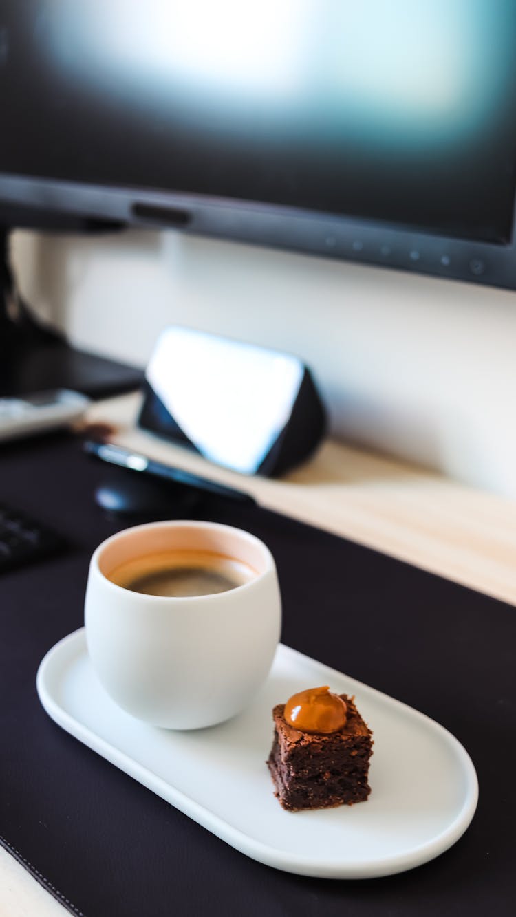 Coffee And Pastry On Desk With Monitor