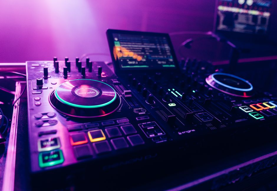 Vibrant nightlife scene featuring an illuminated DJ mixer with colorful lights.