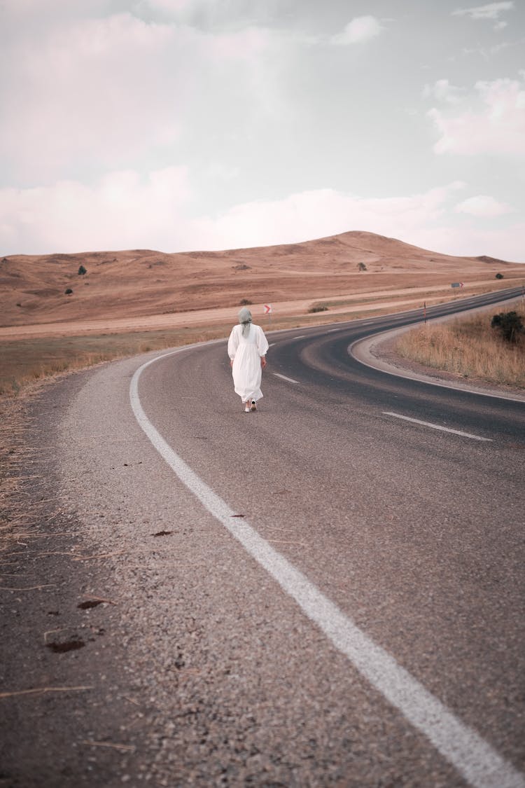 Person In White Dress Walking Along Empty Street 