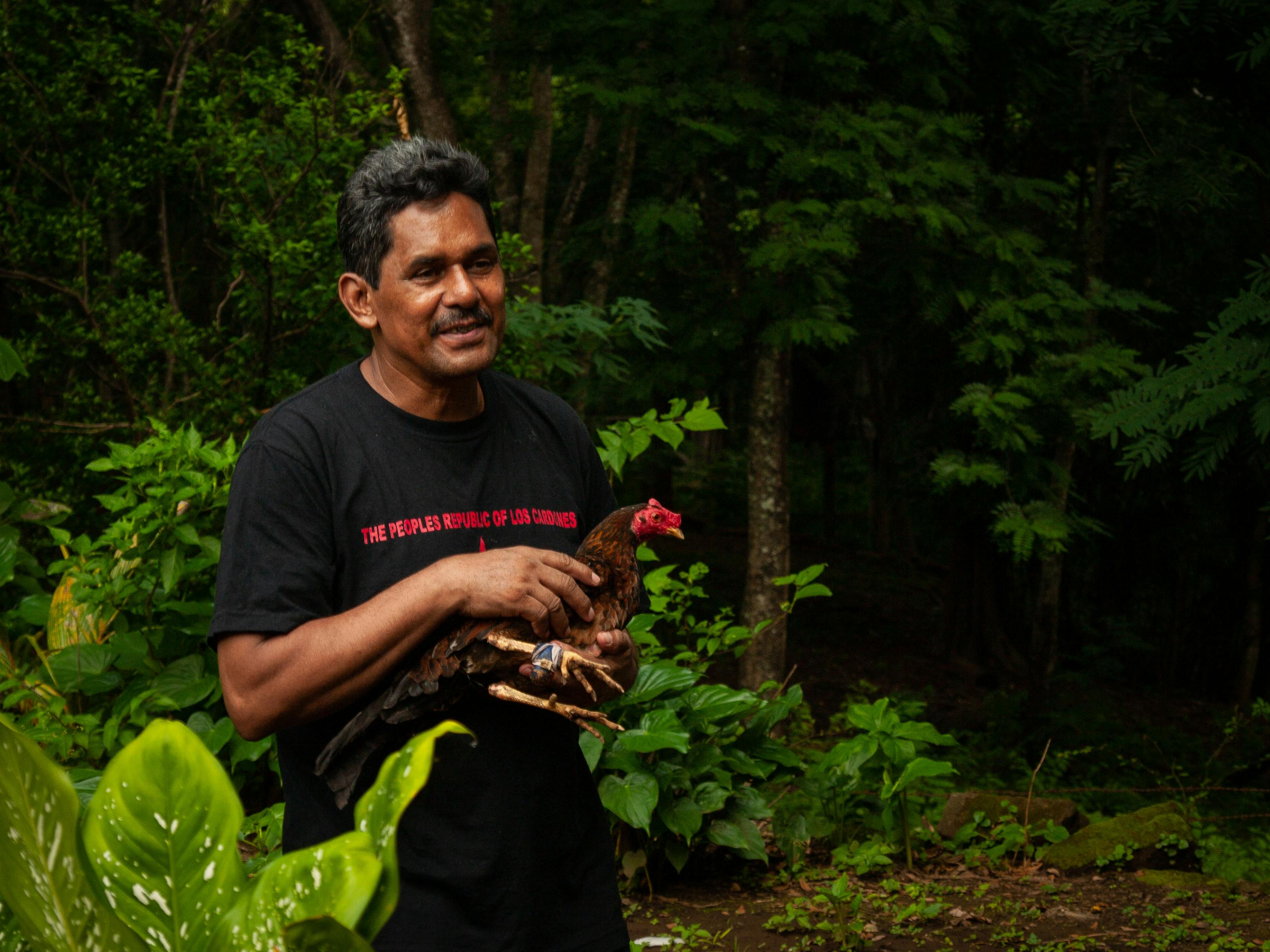 man in the forest holding a chicken