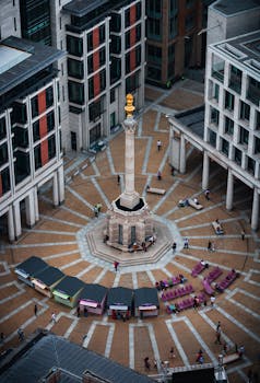 Stunning aerial shot of Paternoster Square in London, showcasing the central column and bustling urban activity.