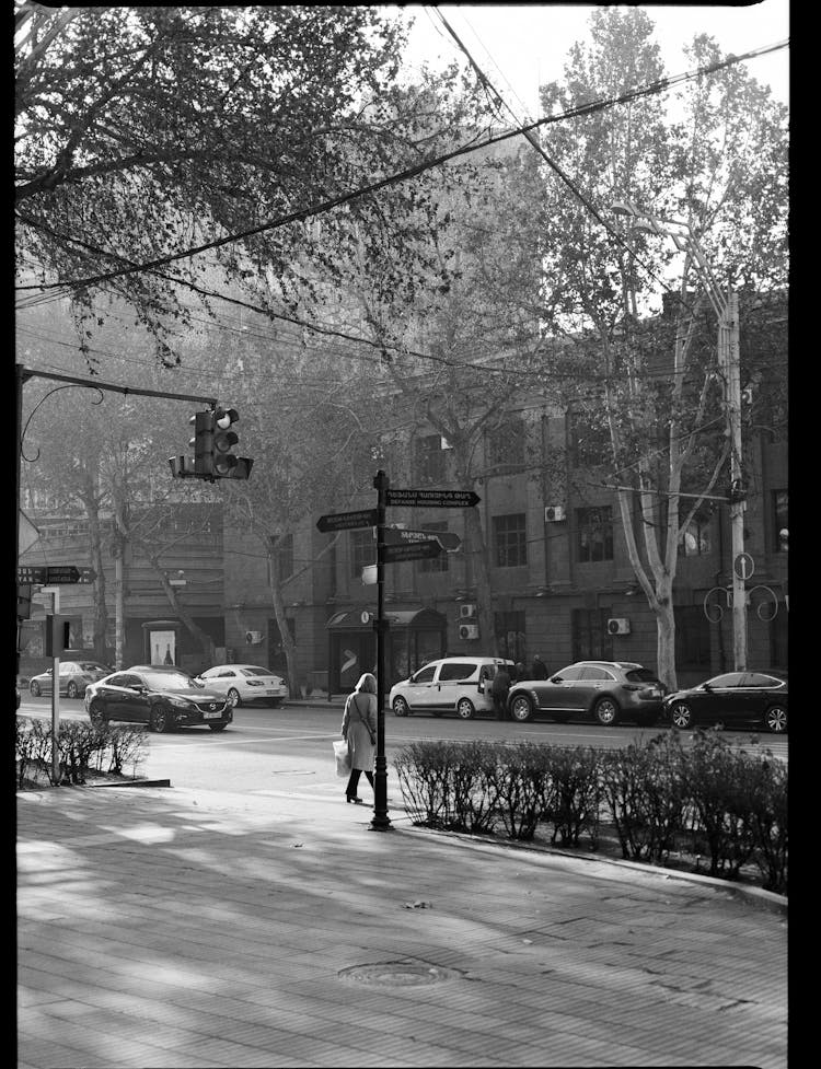 Black And White Photo Of Person Crossing Street