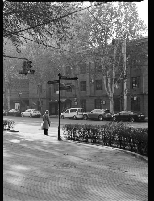 A solitary figure stands on a sidewalk in Yerevan, Armenia, capturing the tranquil morning cityscape.