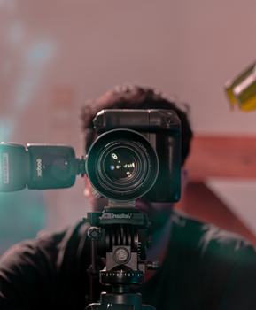A detailed close-up of a DSLR camera with attached flash, capturing the focus ring.