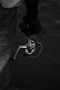 Black and white close-up of a fisherman holding a fishing rod in Lagos, Nigeria.