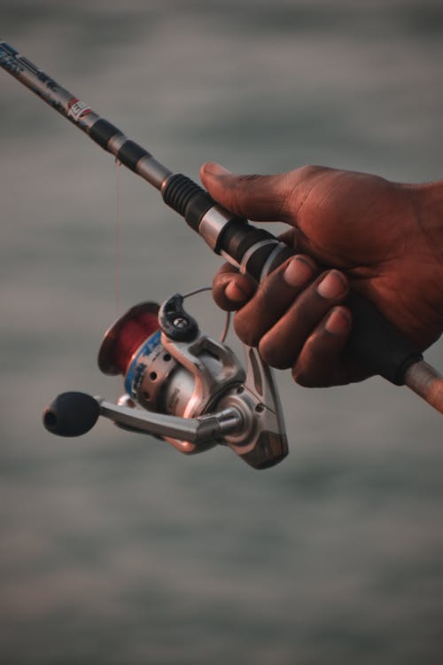 Fishing rod closeup on a prop and water background Stock Photo