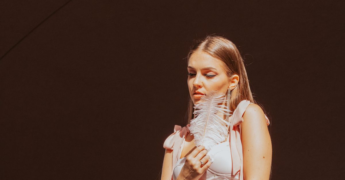 Sofia Richie wearing an elegant cream-colored slip dress on a red carpet, minimal accessories, natural makeup