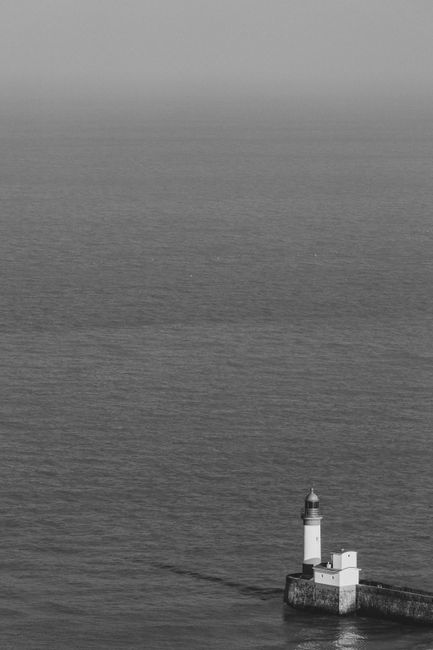 A stunning black and white aerial view of a lighthouse on the coast of Le Tr茅port, France.