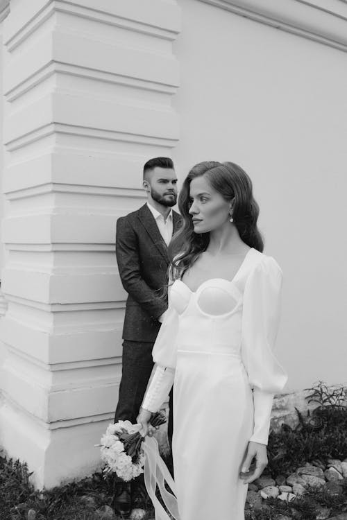 Newlyweds Posing near Building Wall