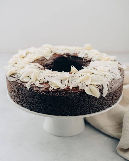 Free Mouth-watering chocolate cake topped with white chocolate shavings on a modern cake stand. Stock Photo