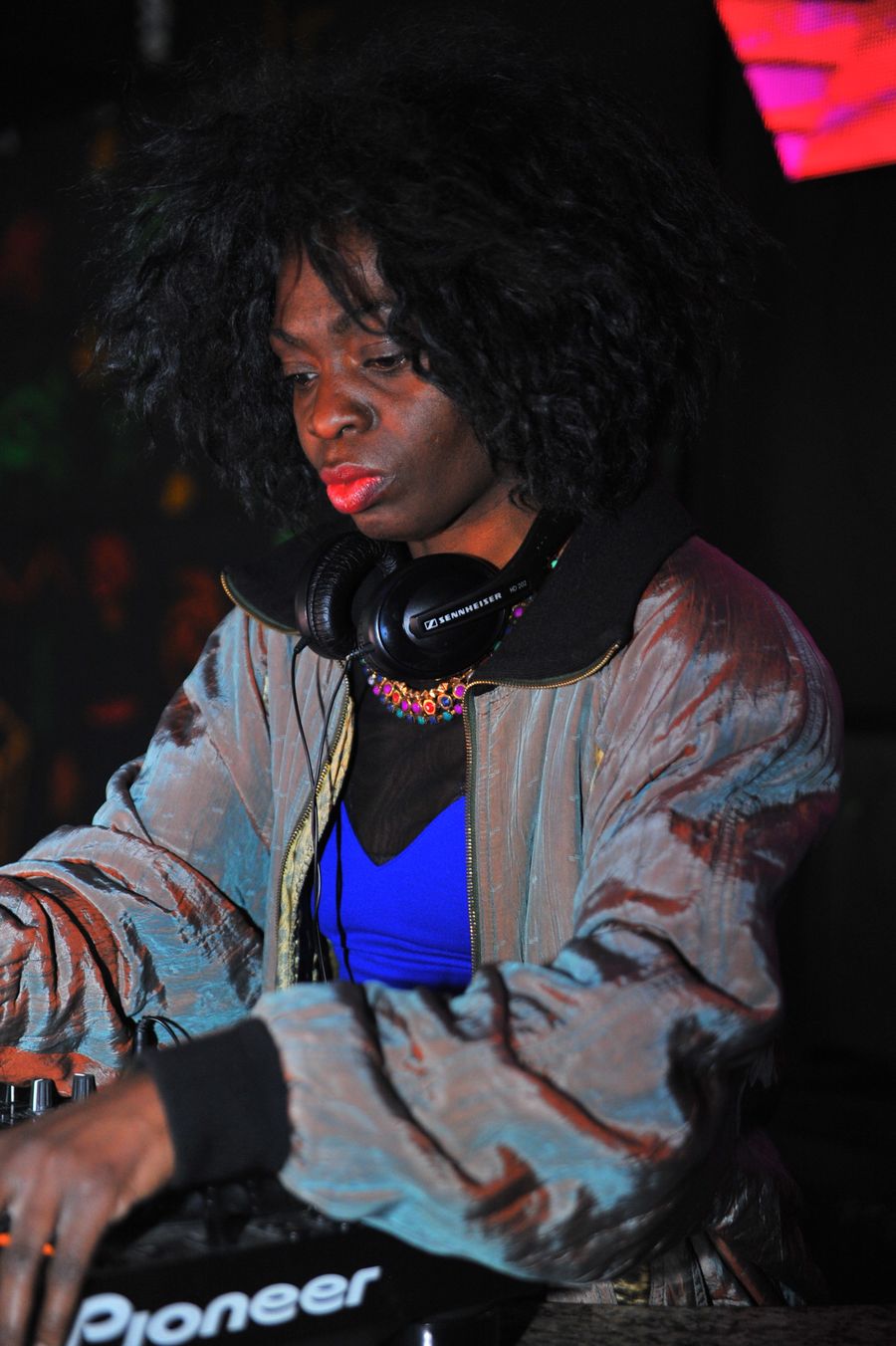 A Black woman DJ mixing at a club