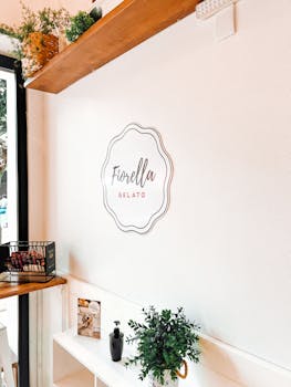 Stylish gelato shop interior featuring Fiorella Gelato logo and indoor plants.
