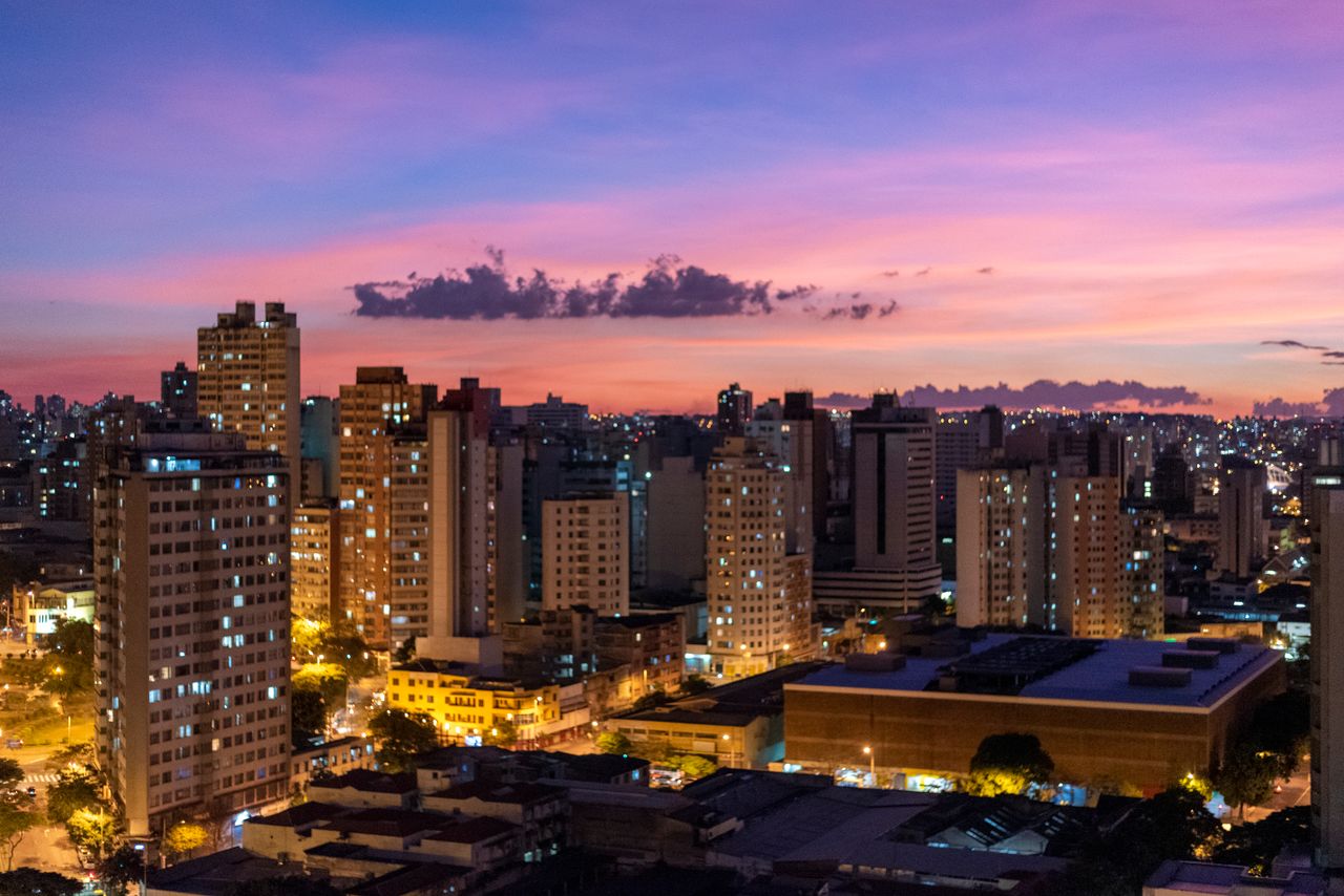 A breathtaking view of Belo Horizonte's skyline during twilight, with colorful skies and city lights illuminating the buildings.