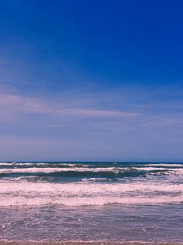 Tranquil seaside scene with gentle waves and a deep blue sky, capturing nature's peacefulness.