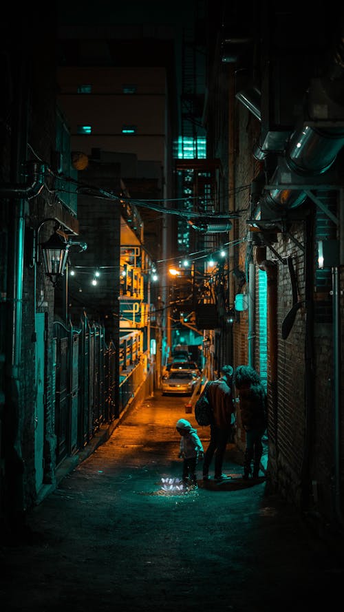 People Standing in a Dark, Narrow Alley between Buildings in City 