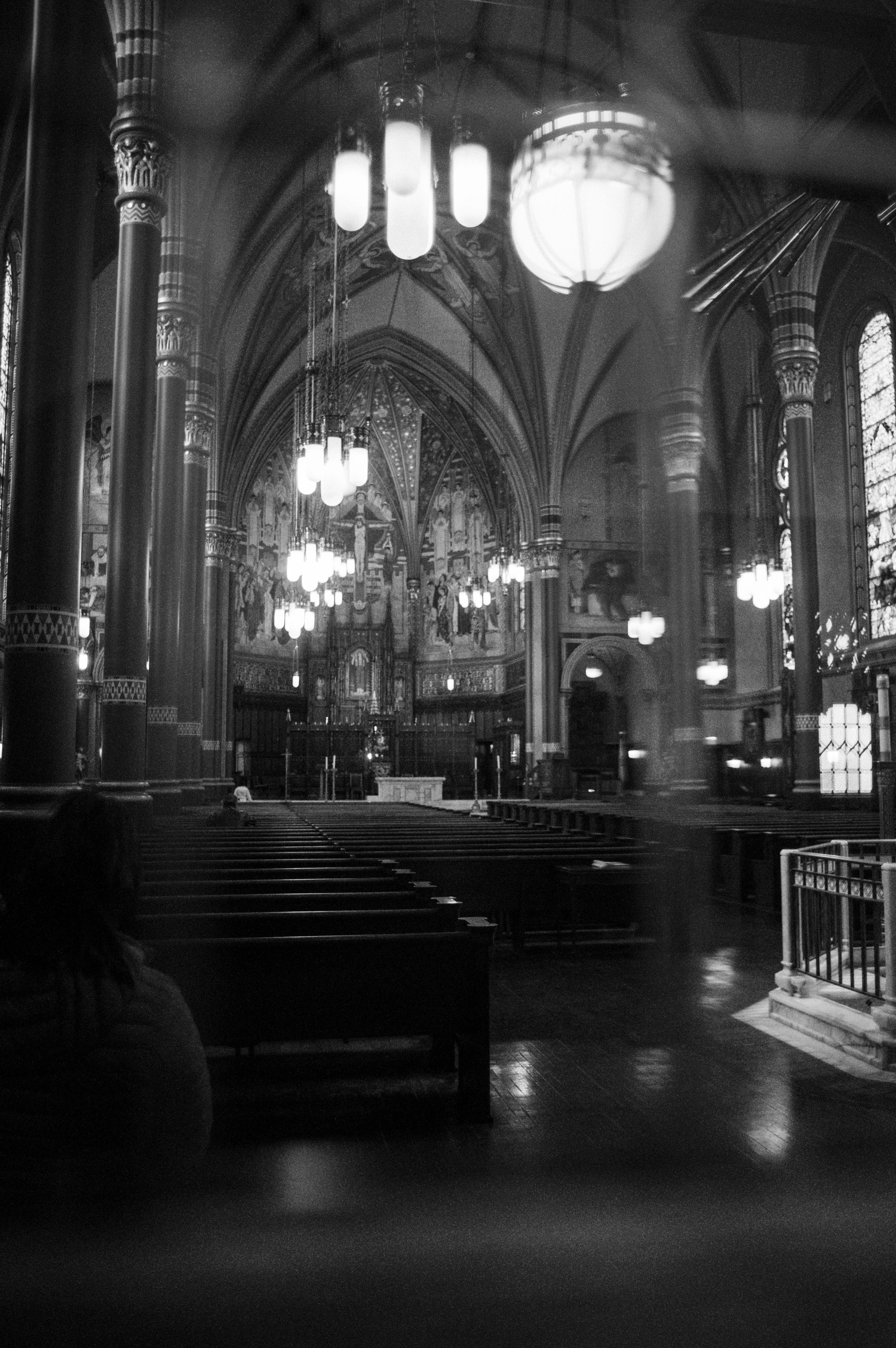 A stunning black and white view of a cathedral interior with gothic architecture and chandeliers.
