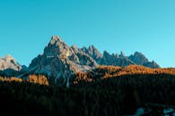 晨光中，雄伟的山峰和秋季的森林沐浴其中