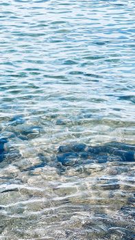 A serene capture of clear blue water revealing stones underneath, perfect for relaxation themes.