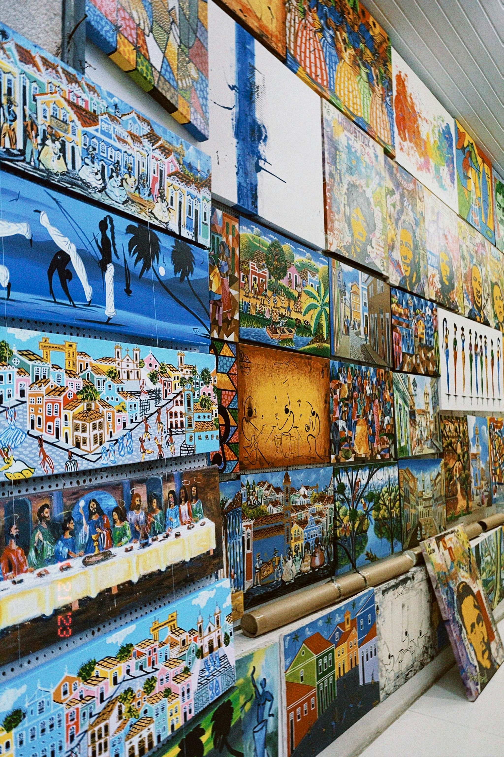 Vibrant and diverse collection of paintings on a gallery wall showcasing various artworks.