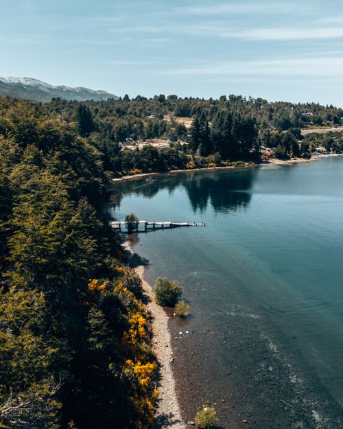 Free A breathtaking aerial view of a serene lake surrounded by lush trees in Villa La Angostura, Argentina during summer. Stock Photo