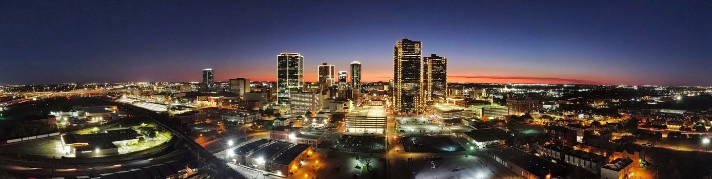 A stunning aerial view of a vibrant cityscape illuminated at twilight.