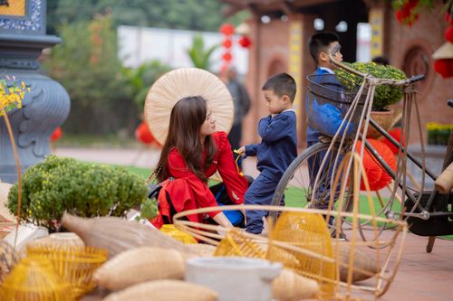 Free A young woman and two children interact at an outdoor market with traditional elements. Stock Photo