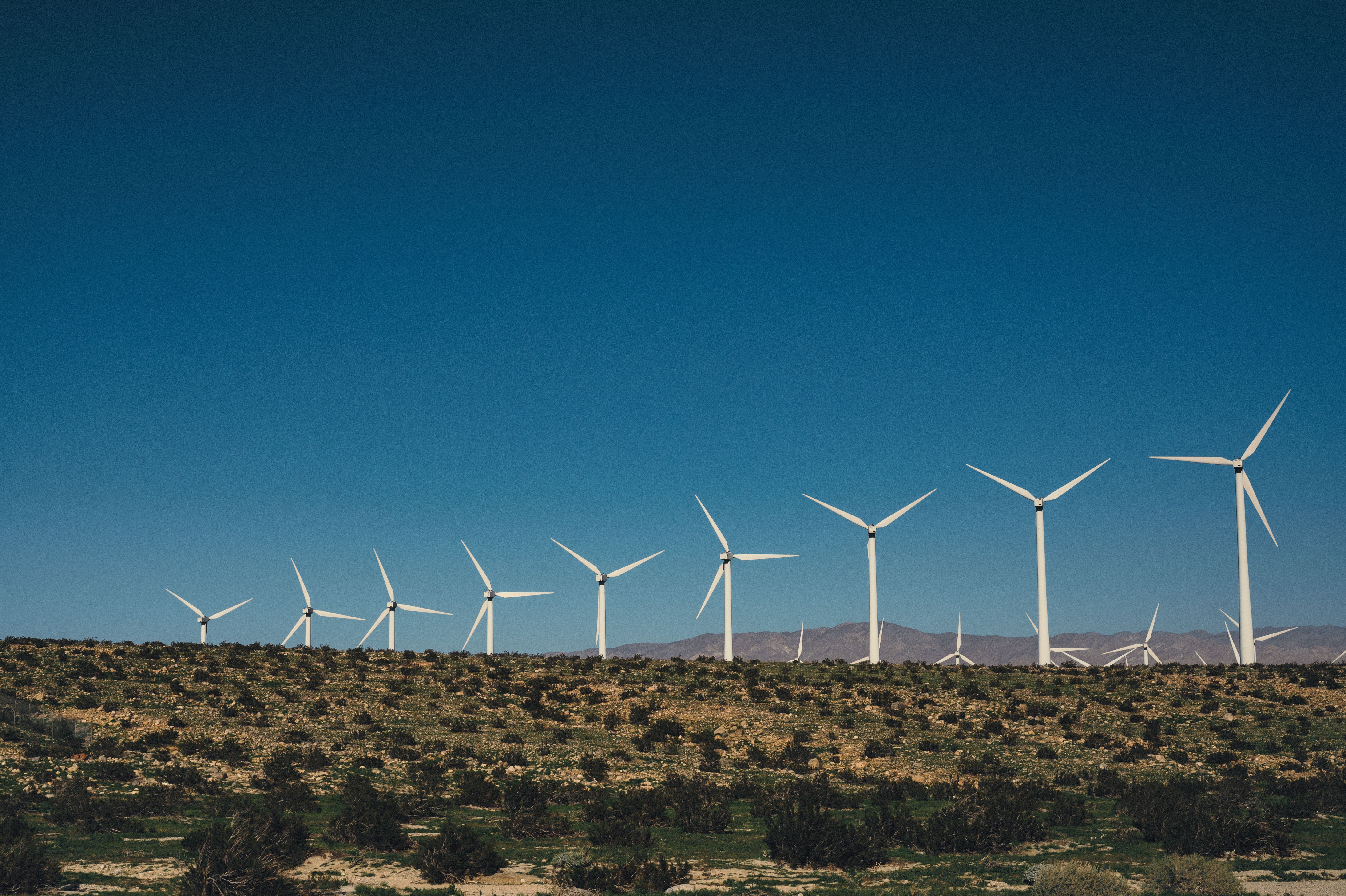 White Wind Turbines on Brown Grass Field Under the Sky · Free Stock Photo