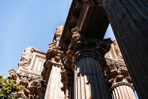 Free Detailed view of ornate architectural columns under a clear blue sky. Stock Photo