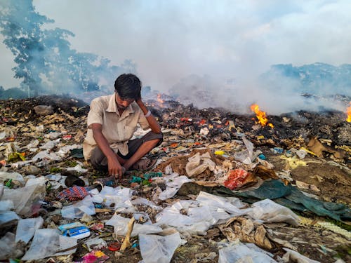 A Man Sitting on a Pile of Trash 
