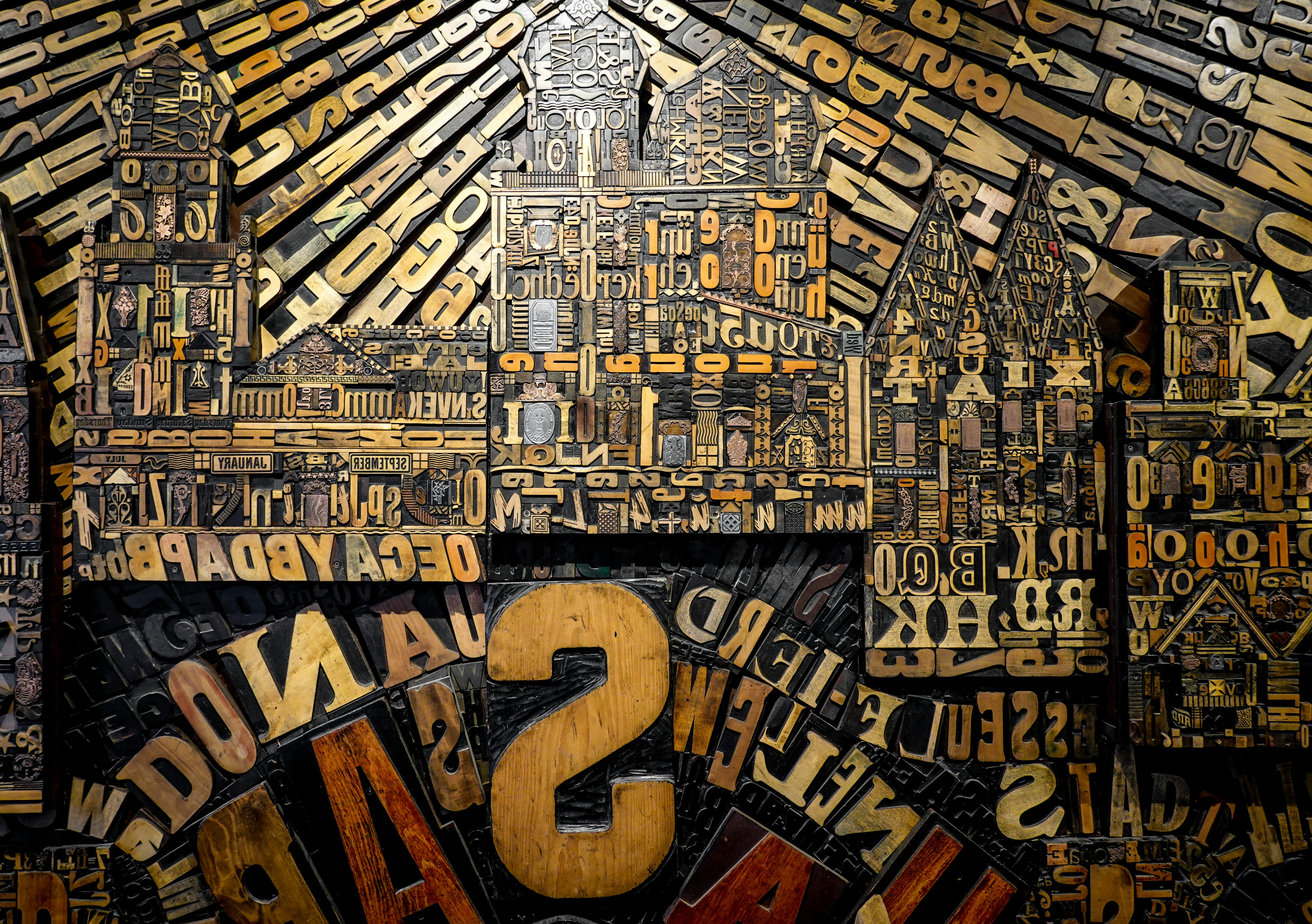 Intricate collage of vintage wooden type letters forming a cityscape.