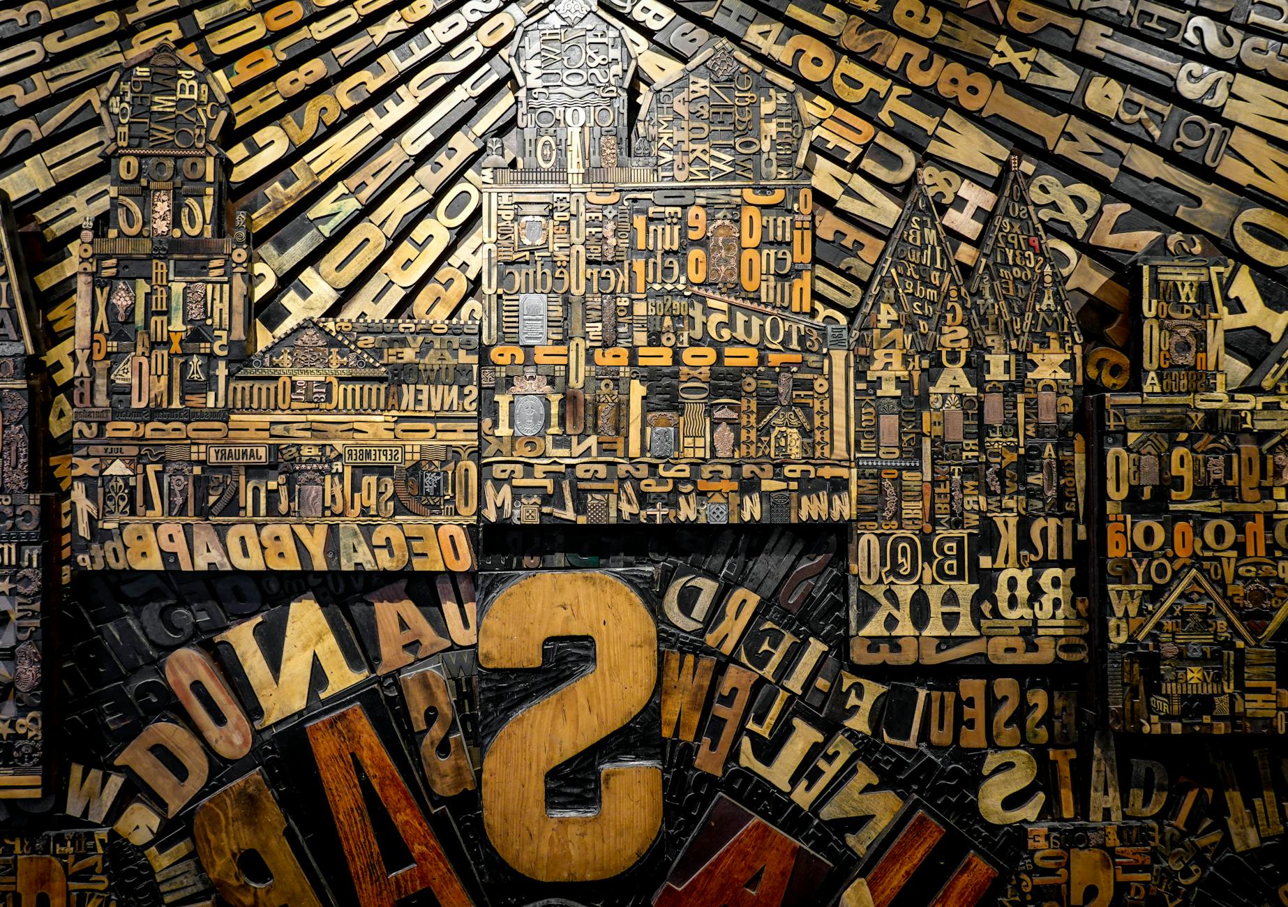 Intricate collage of vintage wooden type letters forming a cityscape.