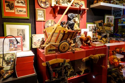 Free Colorful vintage toy display featuring wooden cart and figurines in museum setting. Stock Photo