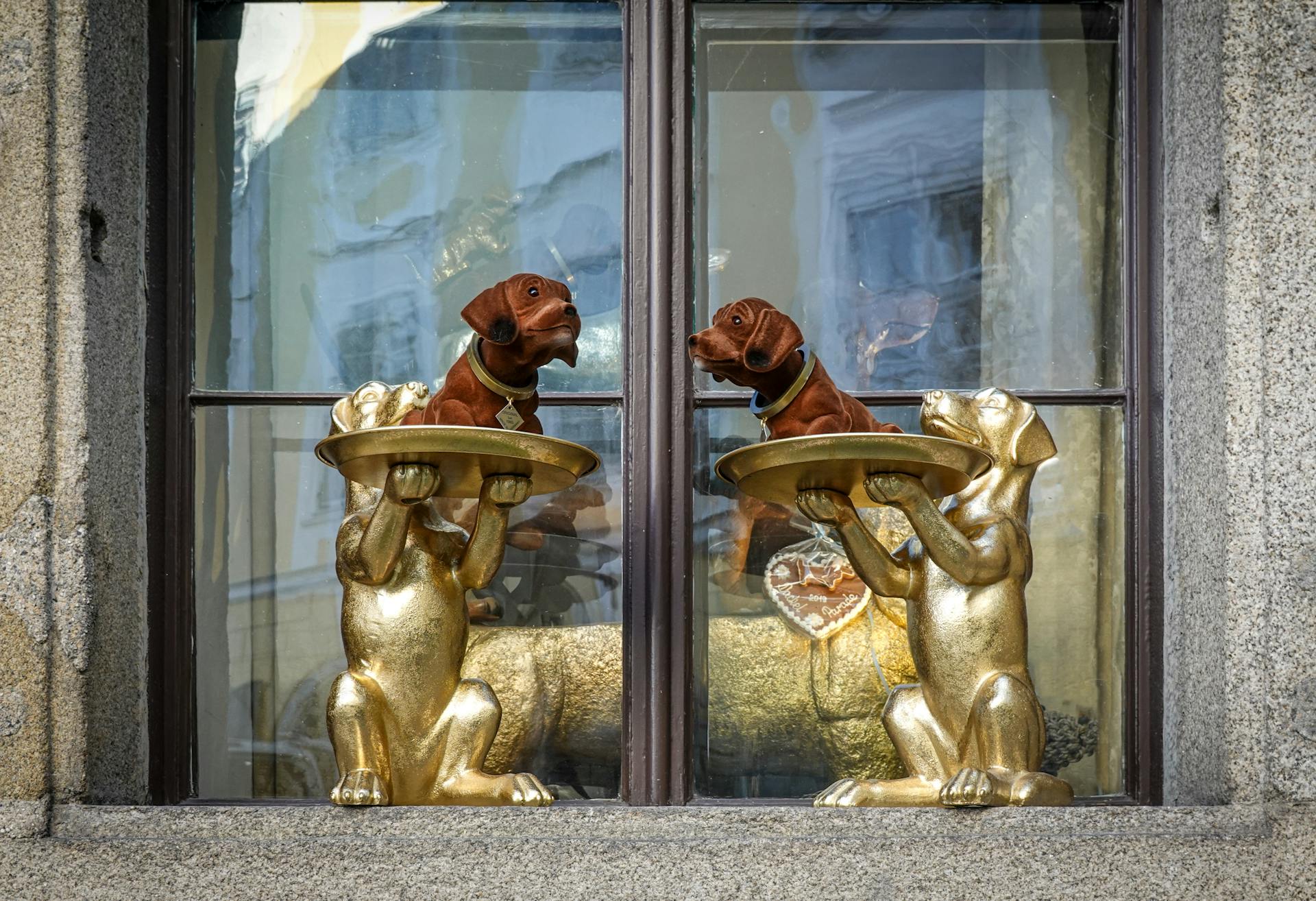 Statues of Golden Dogs in Windowsill