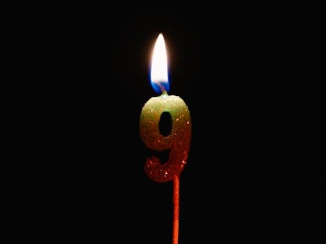 Burning number nine candle against a dark backdrop, perfect for birthdays or anniversaries.