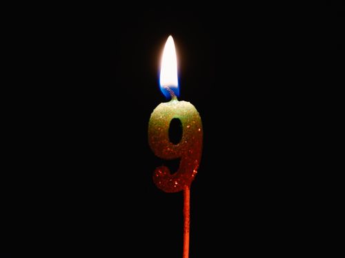 Free Burning number nine candle against a dark backdrop, perfect for birthdays or anniversaries. Stock Photo