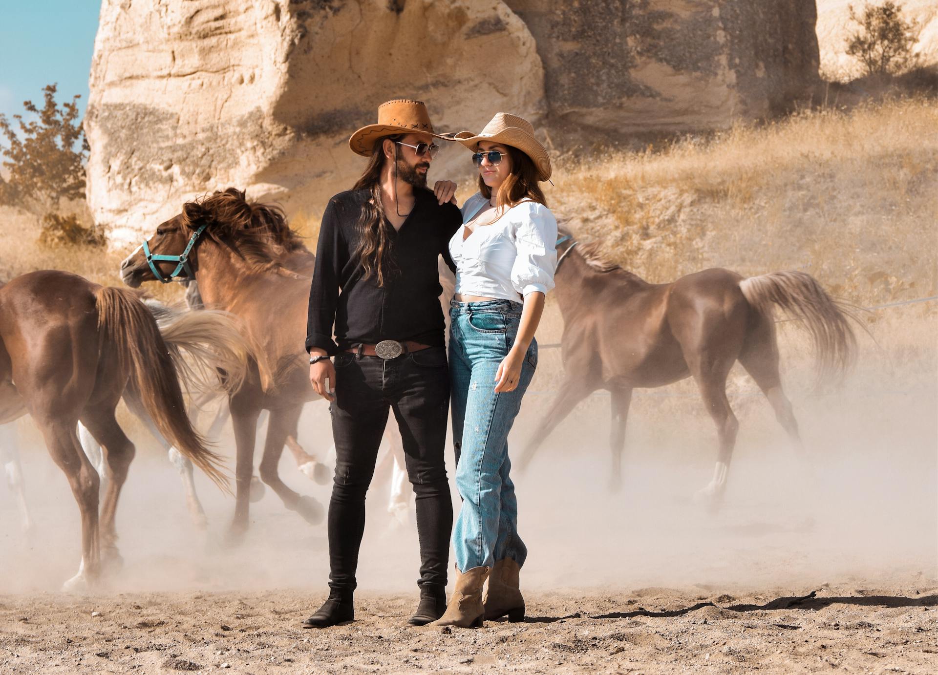 Wild West Style Couple against Running Horses