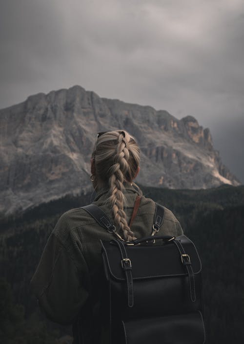 Blonde Woman with Backpack Hiking in Dolomites, Italy