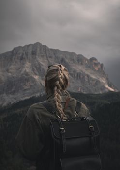 Blonde woman hiking in Santa Cristina Valgardena with a stunning mountain view.
