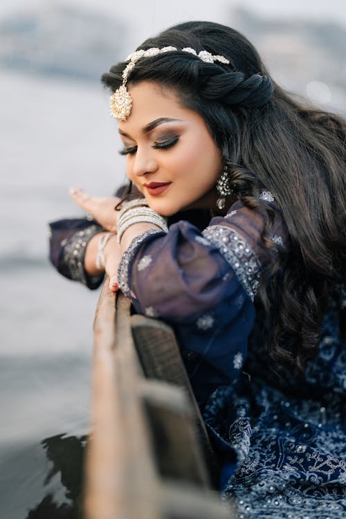 Young Woman in Traditional Dress in Boat on Water