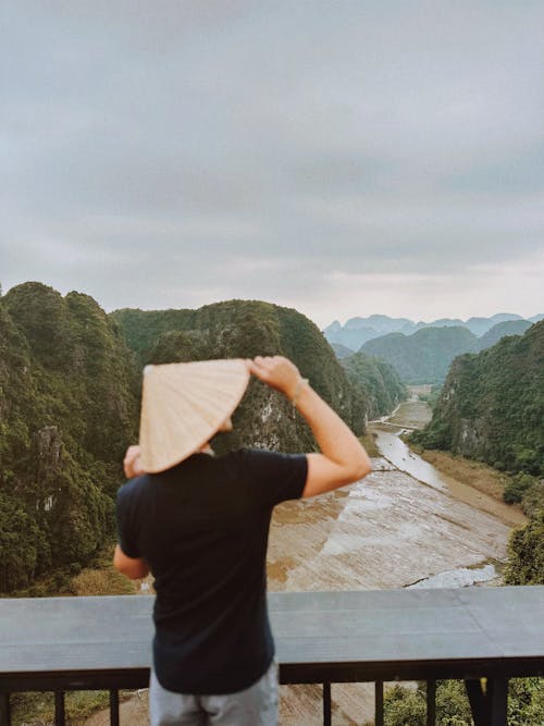 Back View of a Man in a Conical Hat Looking at the River in Ninh Binh, Vietnam