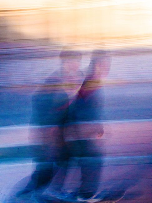 Blurred artistic motion shot of skateboarders, capturing dynamic movement and vibrant colors.