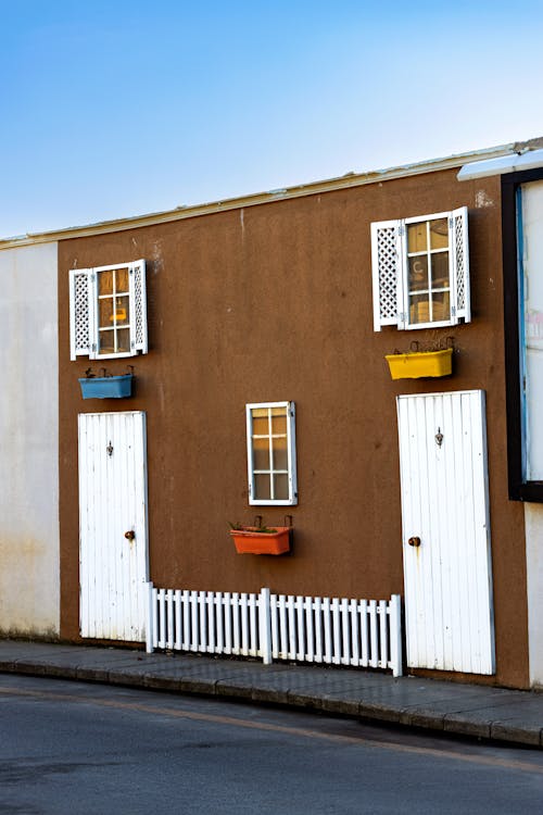 Brown House with White Wooden Doors and Glass Windows 