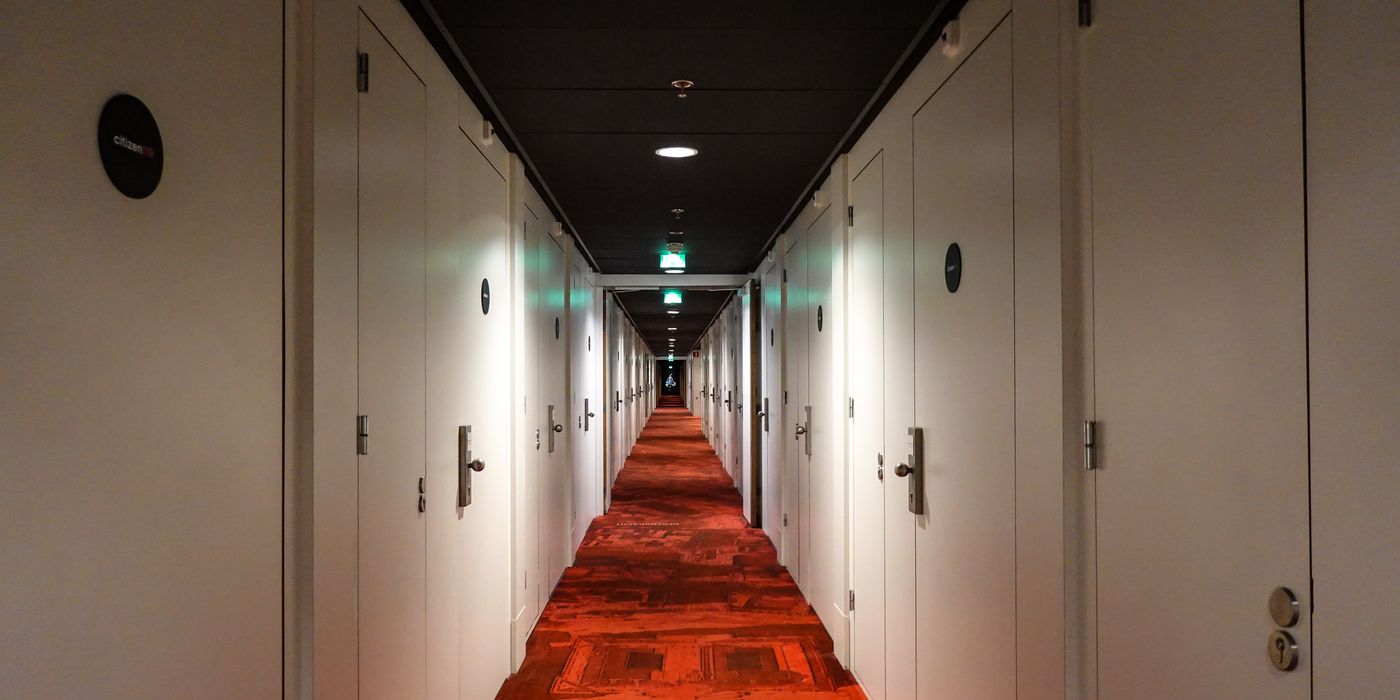 Long symmetrical hotel corridor lined with guest room doors