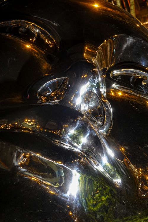 Free Intricate shiny metallic sculpture captured in a close-up vertical shot with reflective surfaces. Stock Photo