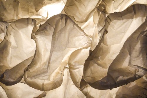 Free Explore the intricate beauty of crumpled paper illuminated by soft light, showcasing texture and depth. Stock Photo