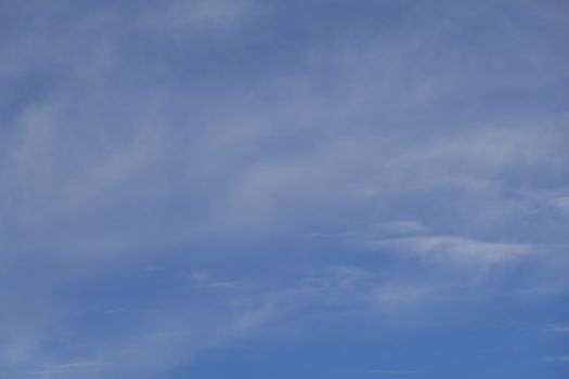 A serene view of a clear blue sky with light and wispy clouds, ideal for backgrounds.