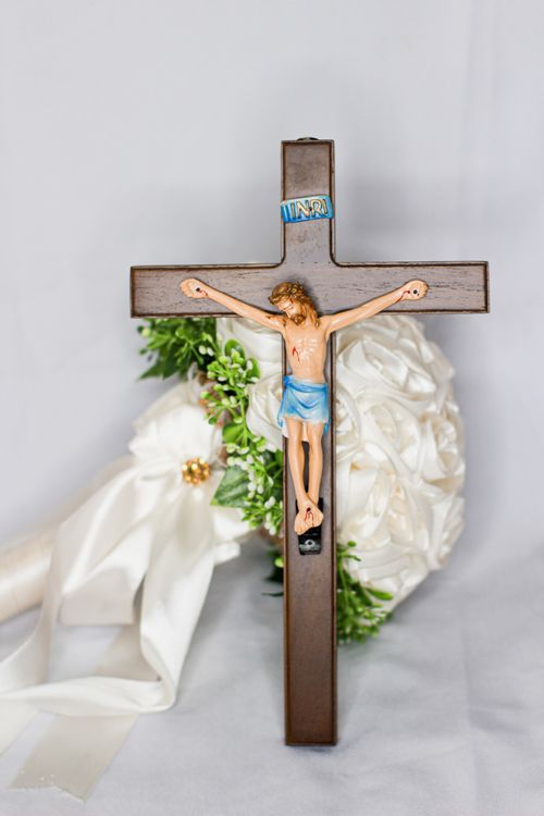 Free Wooden crucifix with Jesus on white background and floral decor, symbolizing Christian faith. Stock Photo