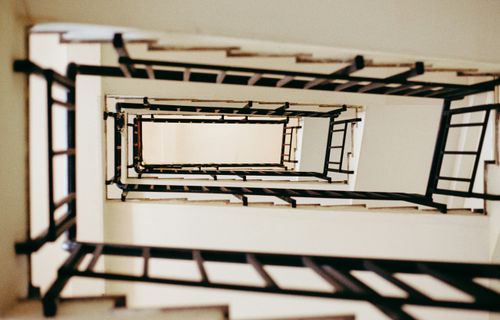 Free A vertical view of a spiral staircase showcasing geometric patterns and contrasting colors. Stock Photo