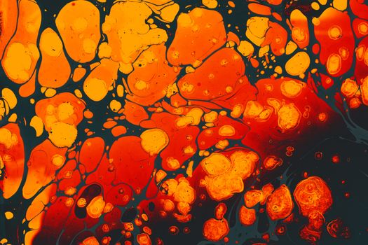Dynamic and colorful abstract fluid art with vibrant orange and black patterns resembling marbled textures.